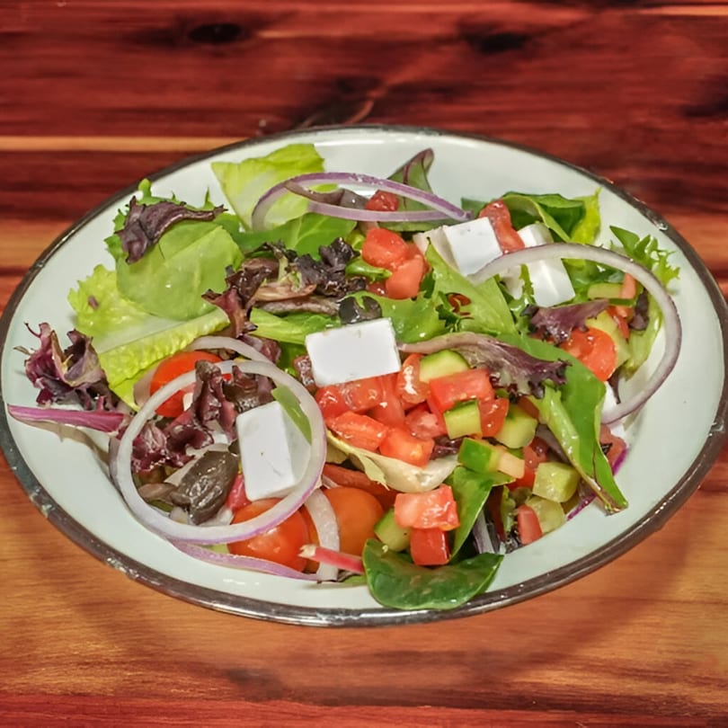 Gili's Kitchen kosher salad with lettuce, tomatoes, cucumbers, red onion, olives, and feta cheese.